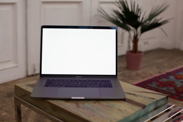 Laptop cu un editor de cod deschis și un terminal, pe biroul unui student la informatică